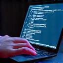 A person working on a laptop with code on screen, surrounded by modern tech interfaces, representing technology startup financing expertise.